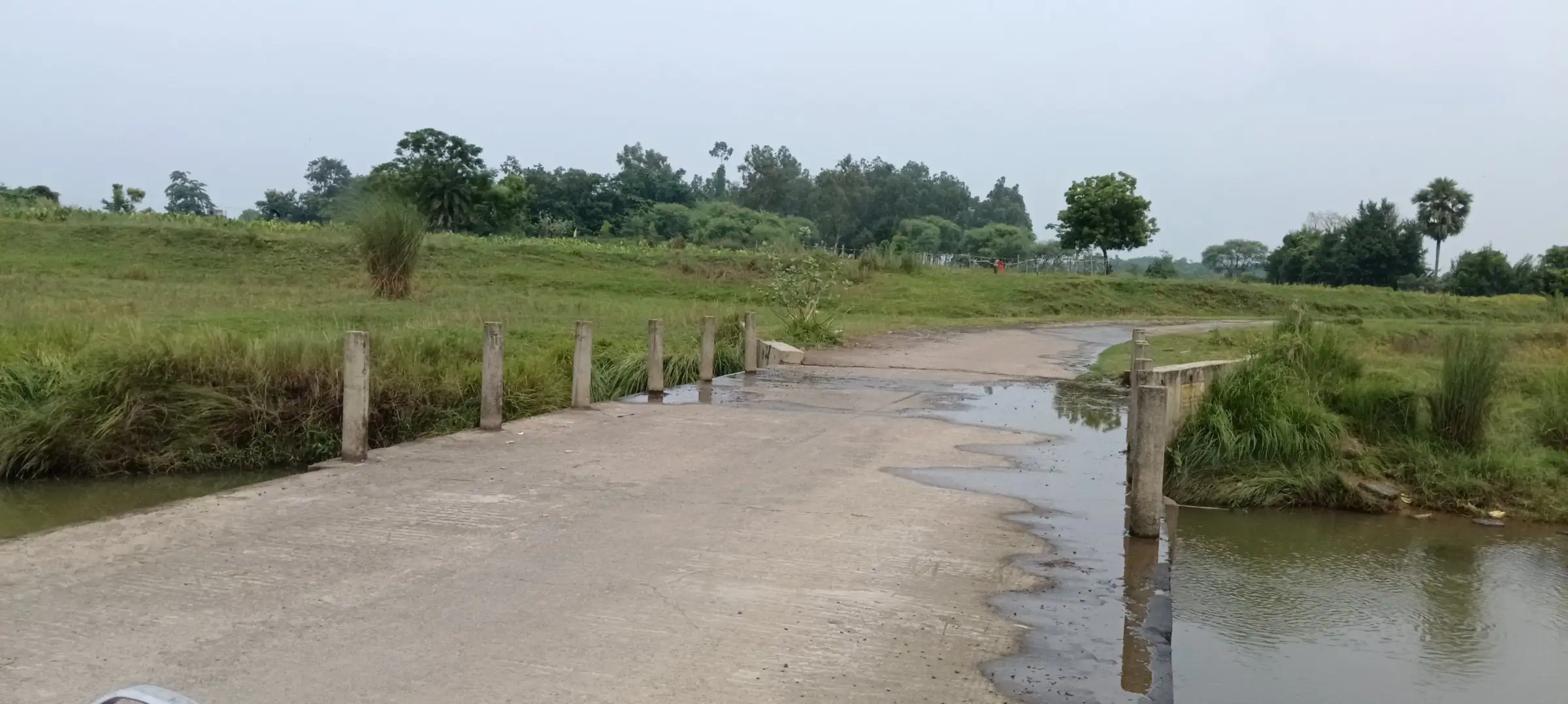 Concrete causeway crossing a slow river