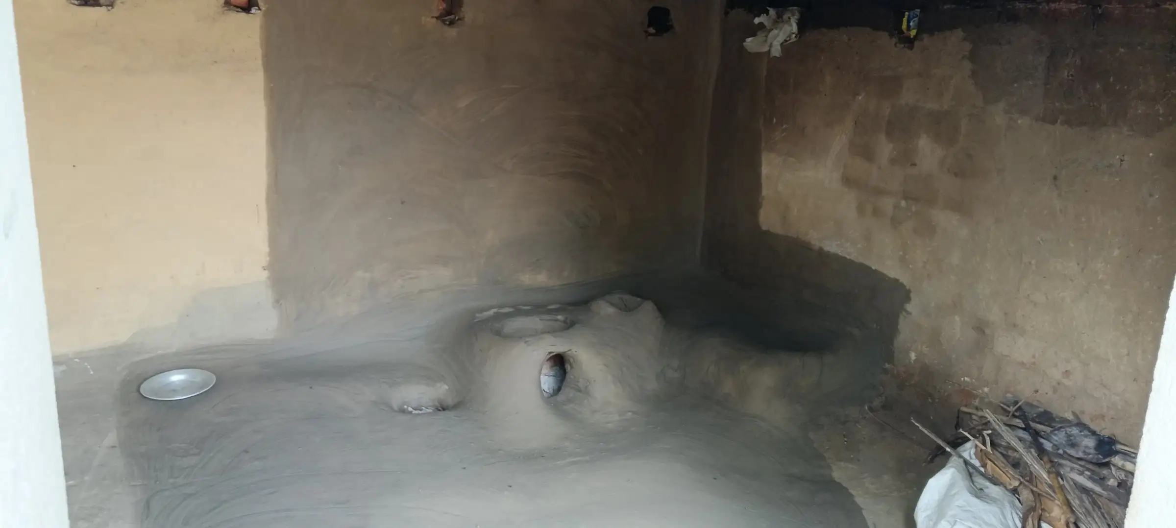 Mud floor and earthen hearth inside a village home