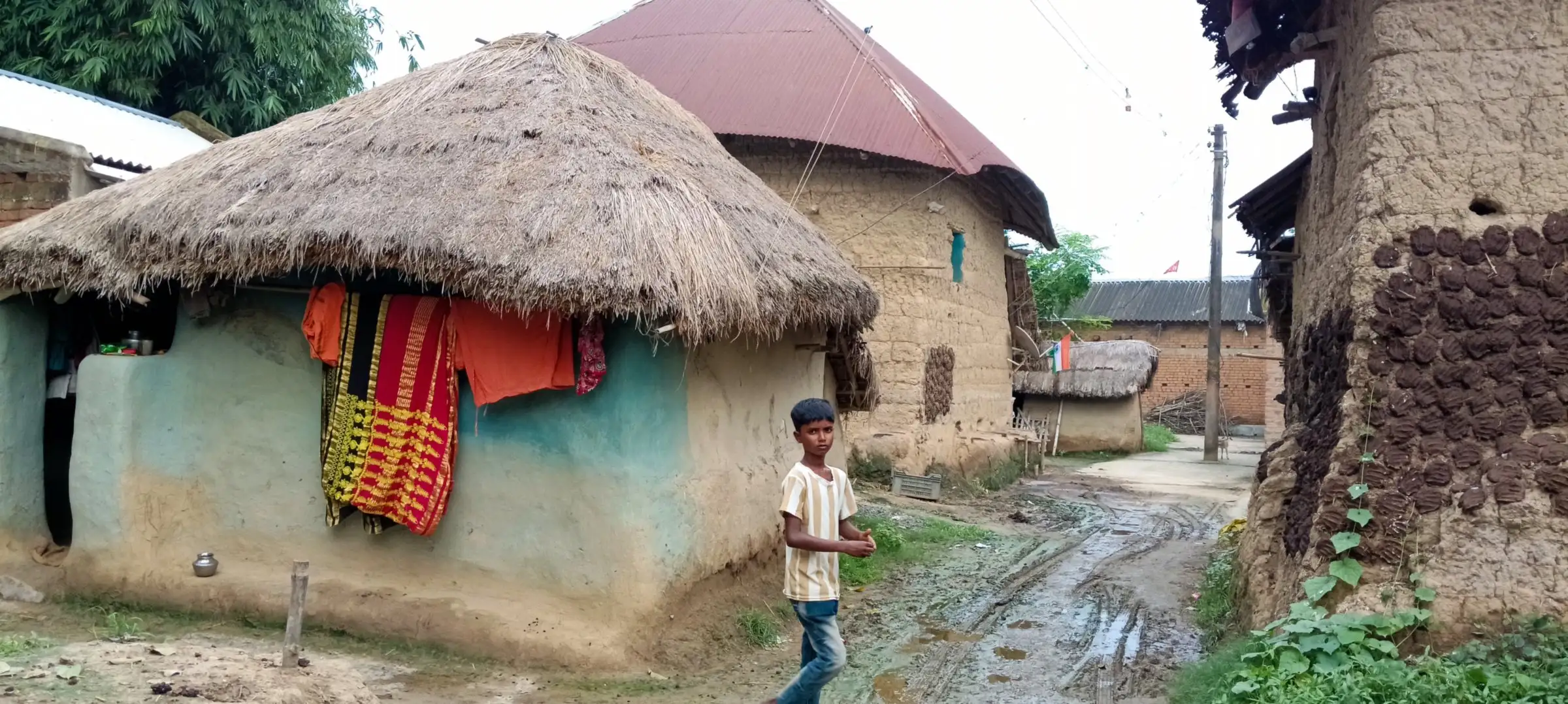 Mud house with colourful saris hung on the wall