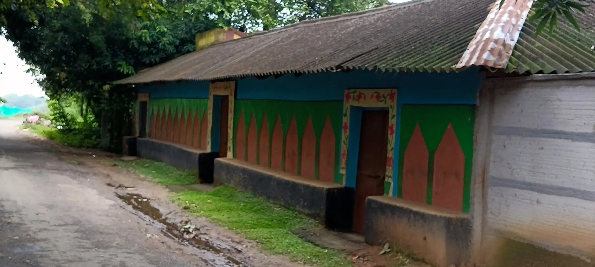 Roadside house painted in green, blue and orange