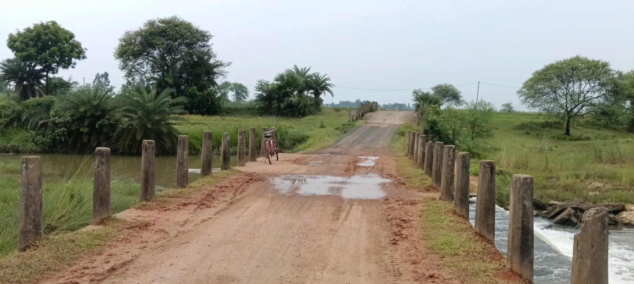 Red-earth road lined with concrete posts