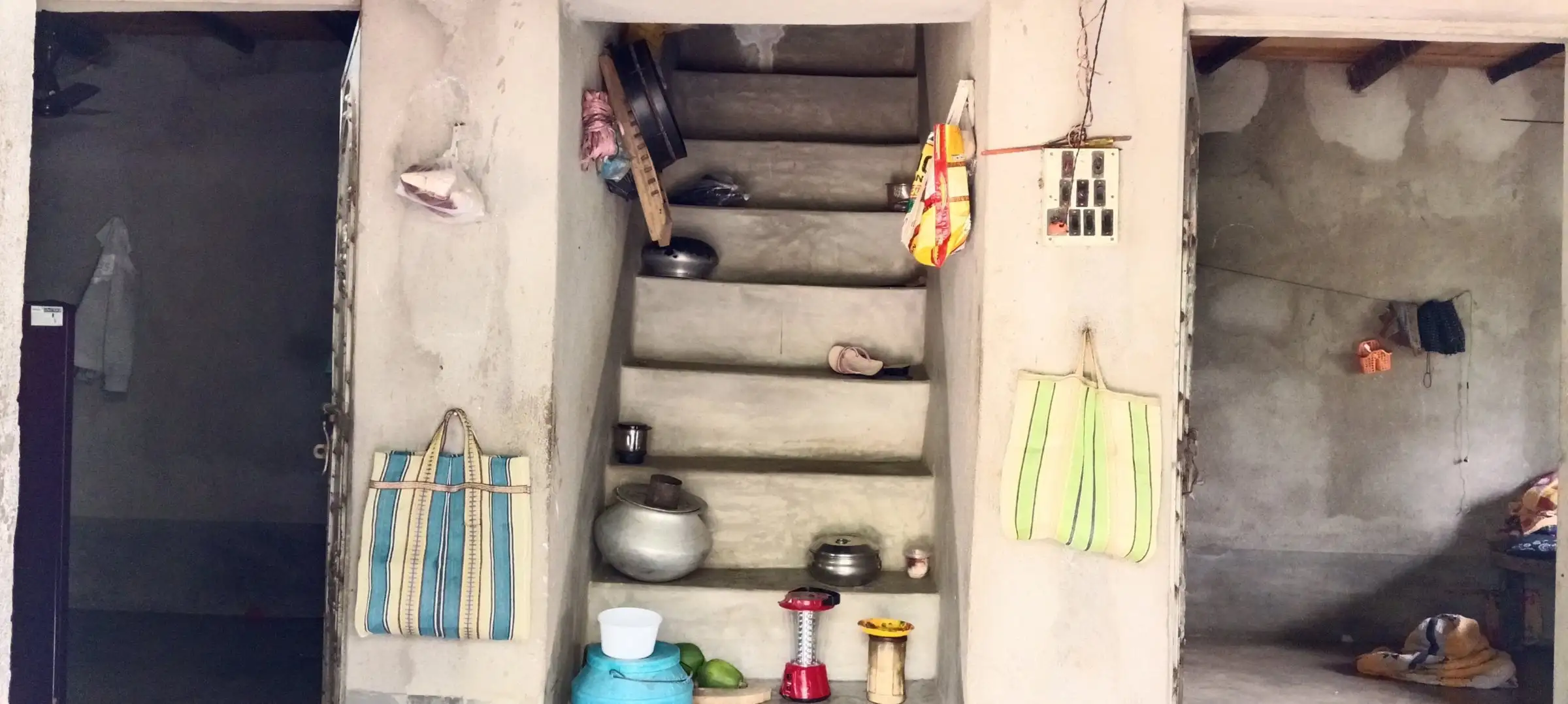 Interior with stairwell, shelves and hanging bags