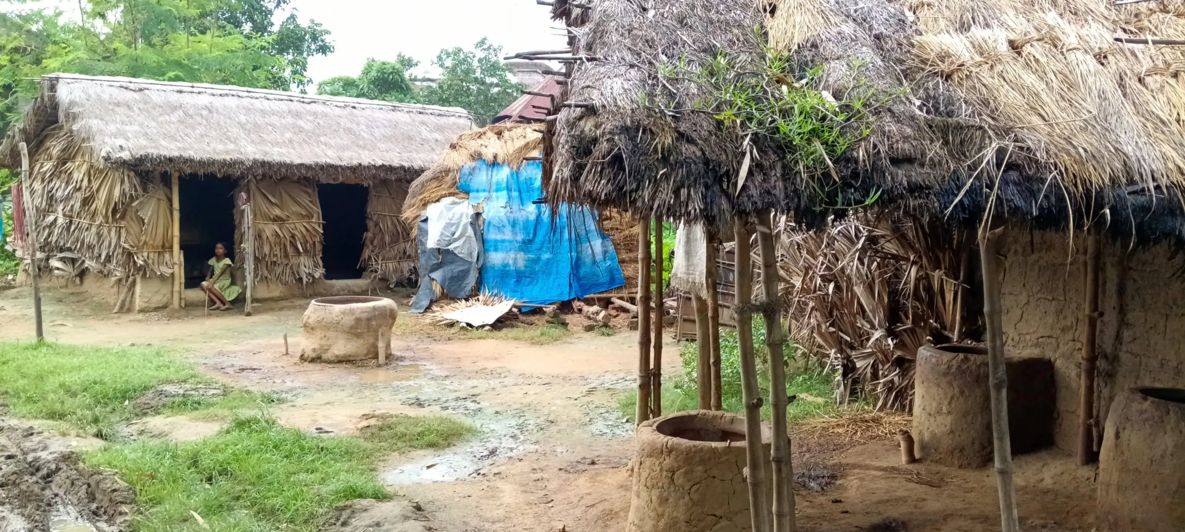 Village courtyard with thatched huts and an earthen well