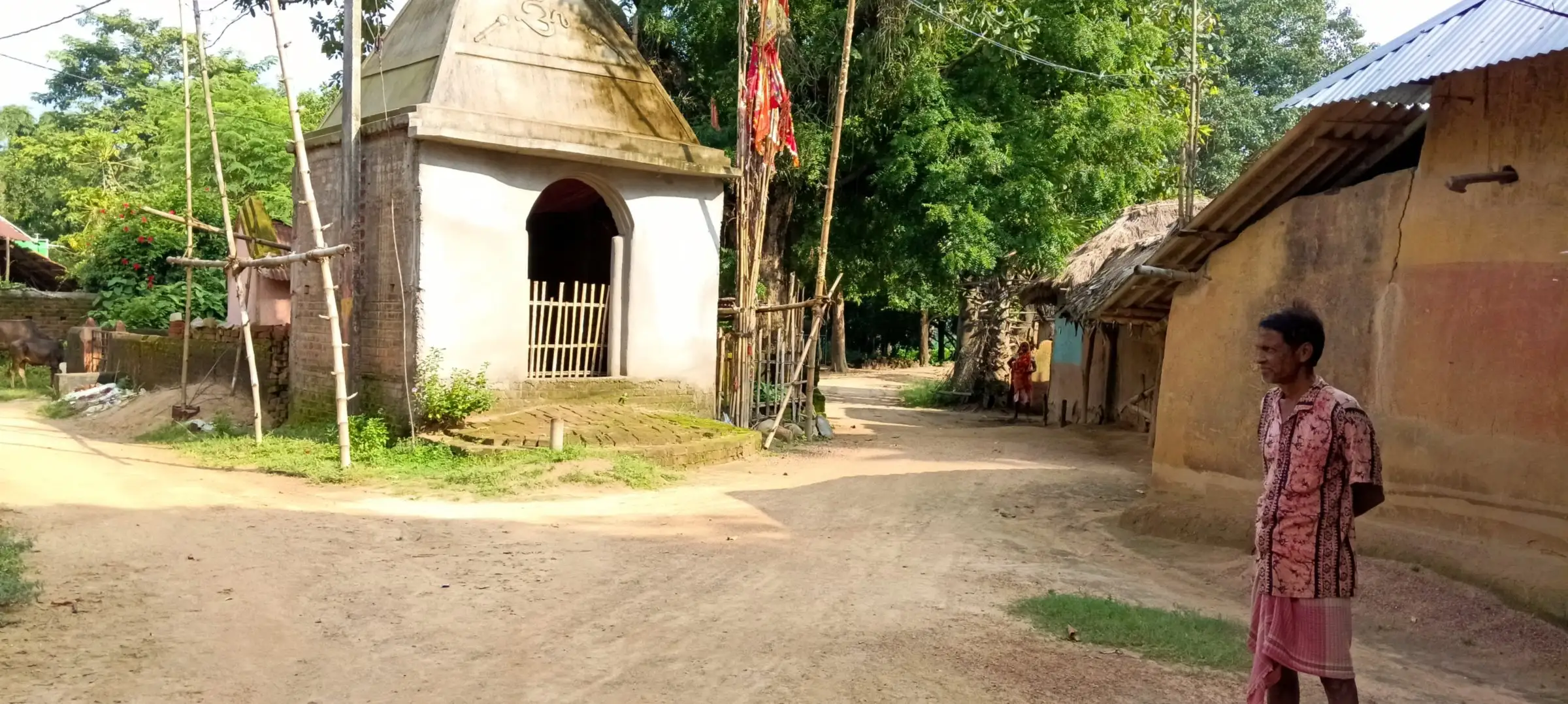 Small whitewashed village shrine on a dirt square