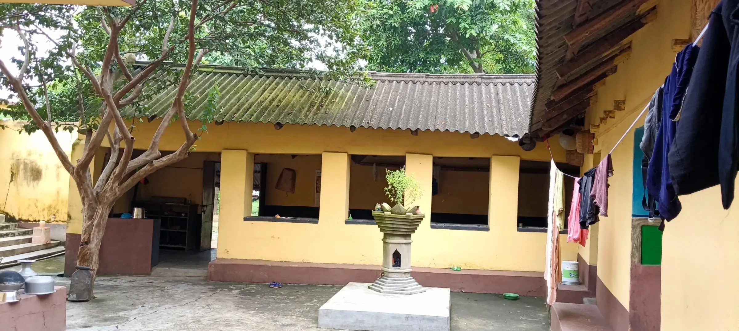 Yellow courtyard house with a tulsi altar in the centre
